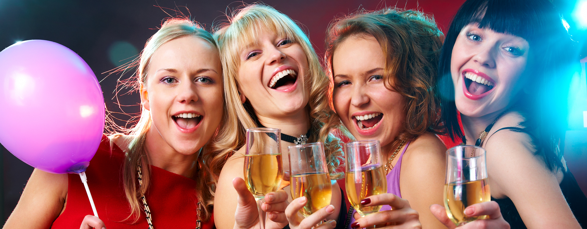 A group of girls celebrating their graduation, holding champagne glasses and smiling